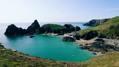 green and brown mountain beside body of water during daytime